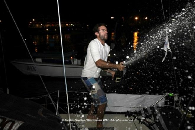 Benoit Marie sprays the victor’s champaign as he arrives on the dock at the finish of the Mini Transat 2013 ©  Jacques Vapillon / Mini Transat http://www.minitransat.fr